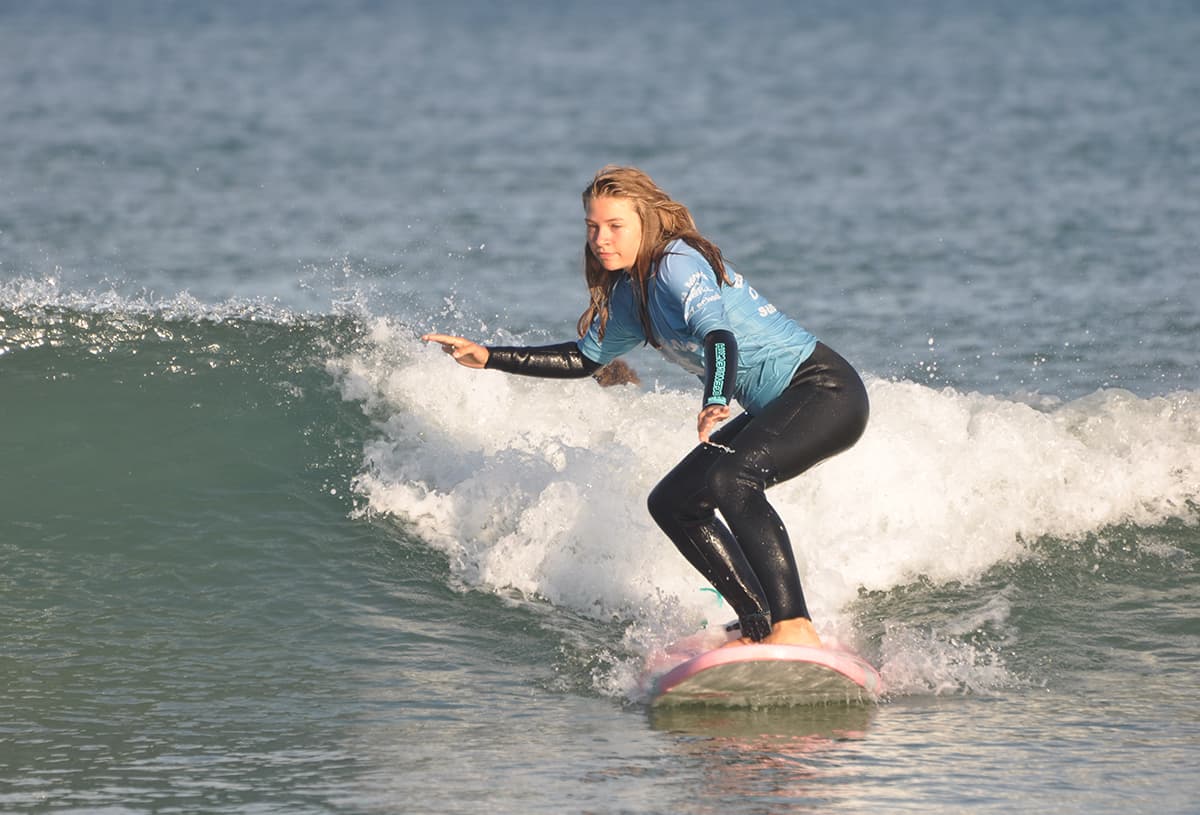 Une surfeuse apprenant à tourner durant un cours de surf à Lacanau