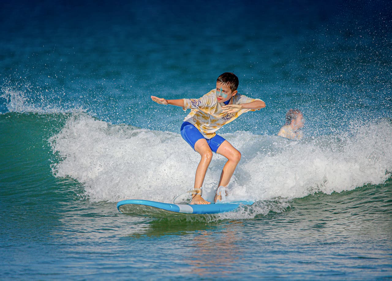 Un garçon très concentré surfant une vague à Lacanau-Océan