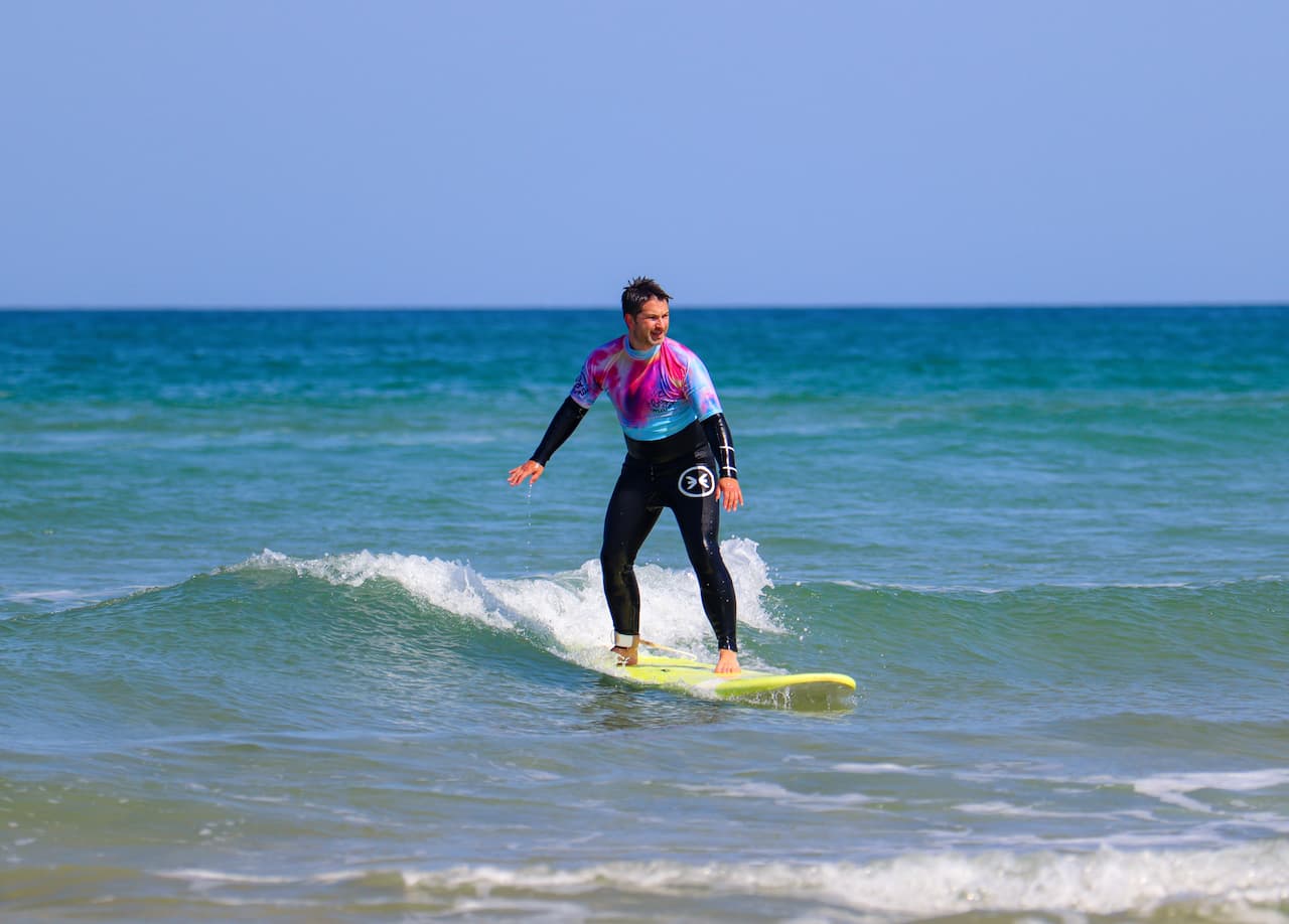 Apprenti surfeur debout sur une vague pendant un stage de surf weekend à Lacanau